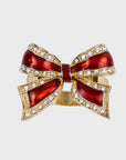 A red and gold bow-shaped napkin ring with rhinestone embellishments.