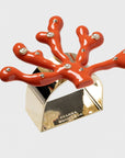 A set of coral-colored napkin rings with an intricate design