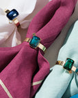 Napkin rings with gemstone-like ends on pink and blue napkins.