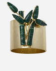 A gold-colored bamboo napkin ring with a jungle green leaf pattern on top.