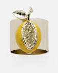 A gold-colored napkin ring designed to resemble a lemon with a yellow rind