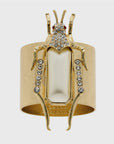 A gold-colored napkin ring featuring a pearl-like grasshopper motif with detailed legs and antennae
