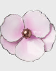 A pink enamel flower napkin ring with a metallic center and silver edging.