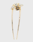 Gold hairpin with bee design on a light gray background