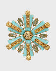 A star-shaped brooch with turquoise and gold-colored stones
