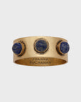 A gold-colored napkin ring featuring a lapis lazuli stone
