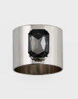 A silver napkin ring with a dark gray crystal stone set in the center, against a white background.