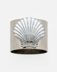 A silver-colored napkin ring featuring a painted shell design in white.