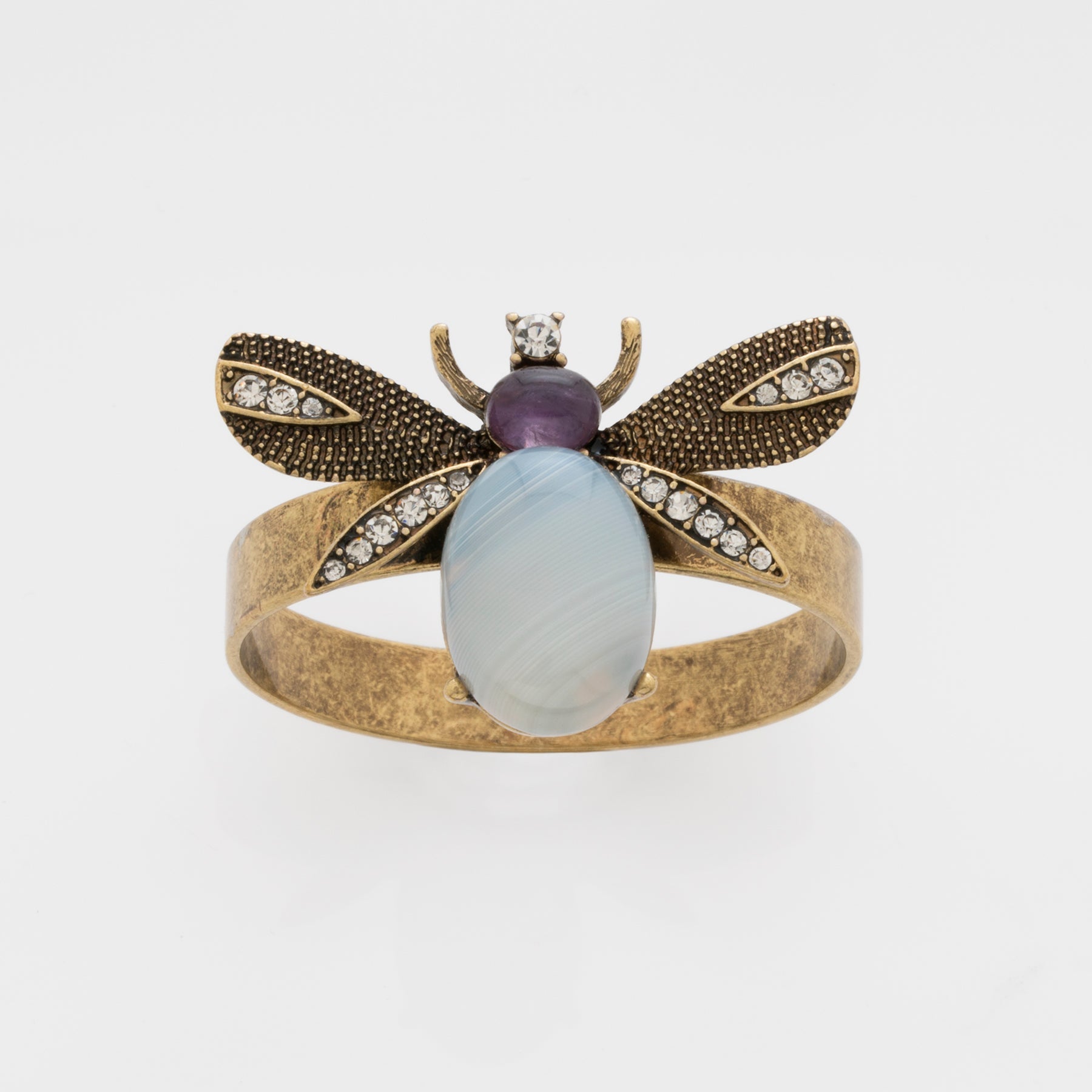 A napkin ring featuring a winged bug design with antique gold finish and a semi-precious agate stone body.