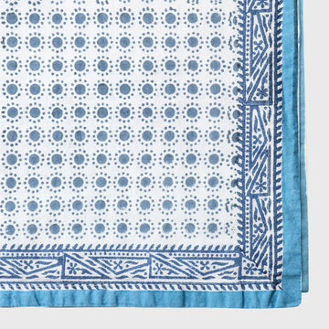 Blue and white patterned fabric with geometric designs on a light gray background