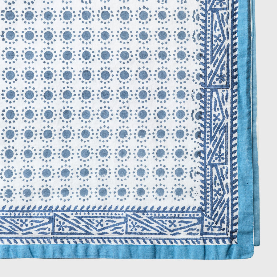 Blue and white patterned fabric with geometric designs on a light gray background