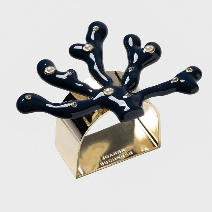 A navy blue coral-shaped napkin ring with gold detailing and hand-set stones.