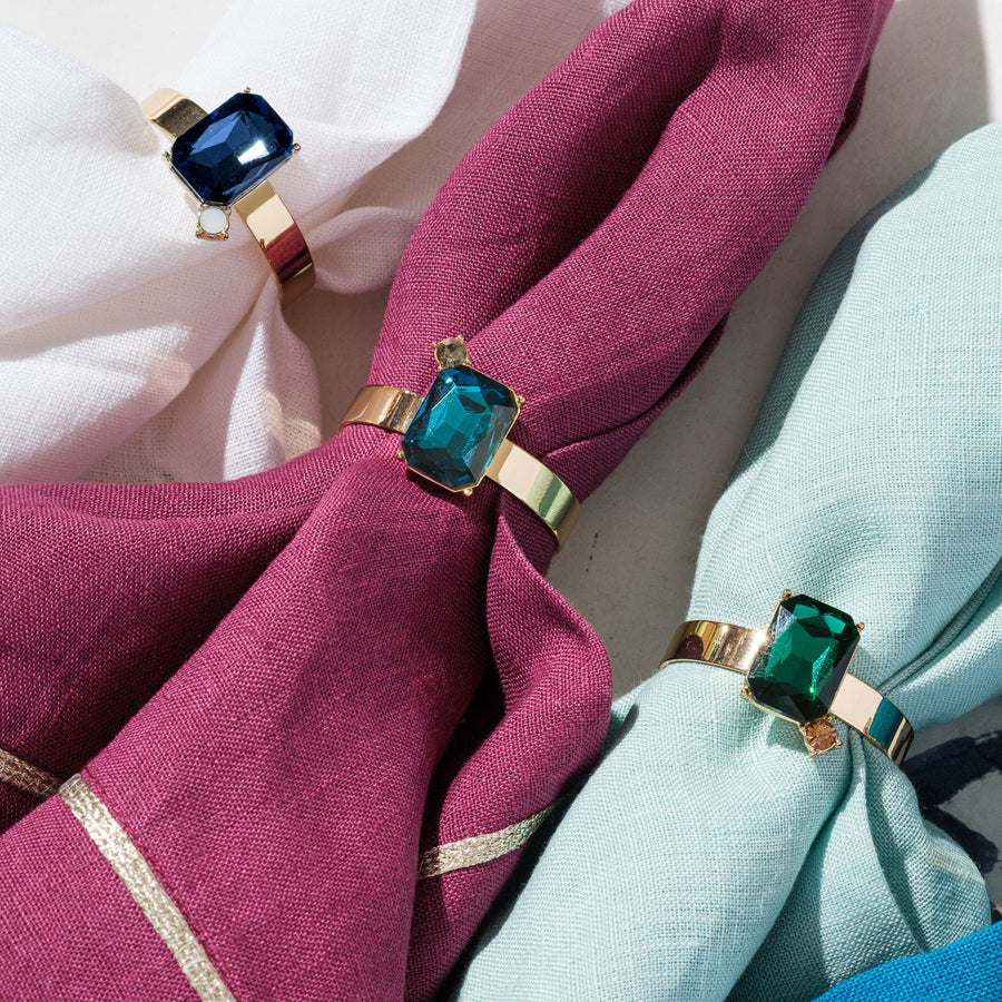 Napkin rings with gemstone-like ends on pink and blue napkins.