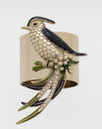 A decorative napkin ring featuring a navy and gold bird perched on a napkin.