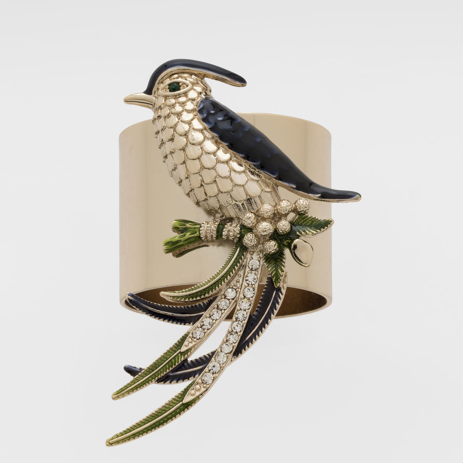 A decorative napkin ring featuring a navy and gold bird perched on a napkin.
