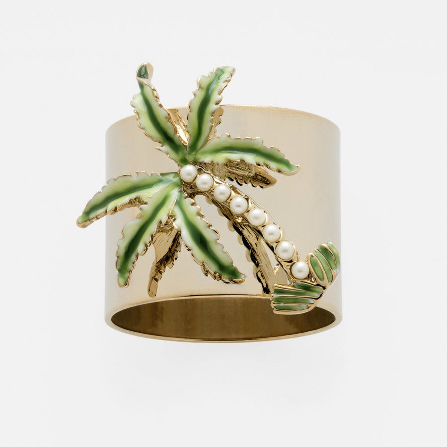 A gold-colored napkin ring featuring a hand enameled palm tree with green fronds and faux-pearl trunks.