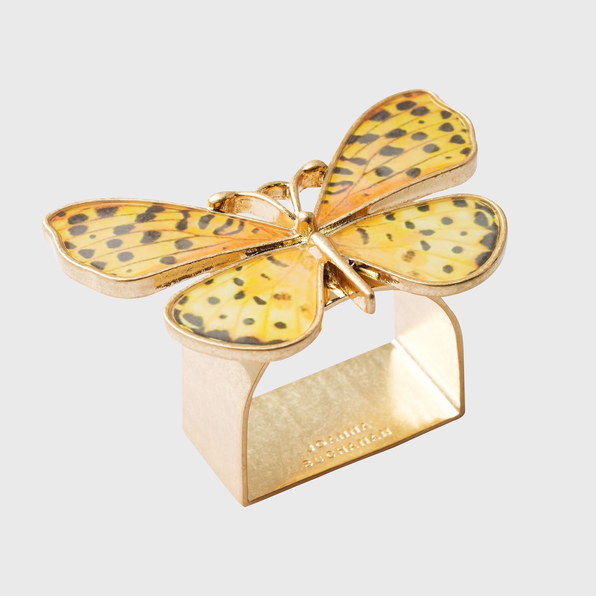 A gold-colored napkin ring featuring a yellow butterfly with black spots on its wings.