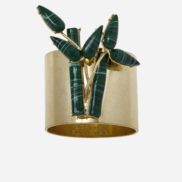 A gold-colored bamboo napkin ring with a jungle green leaf pattern on top.