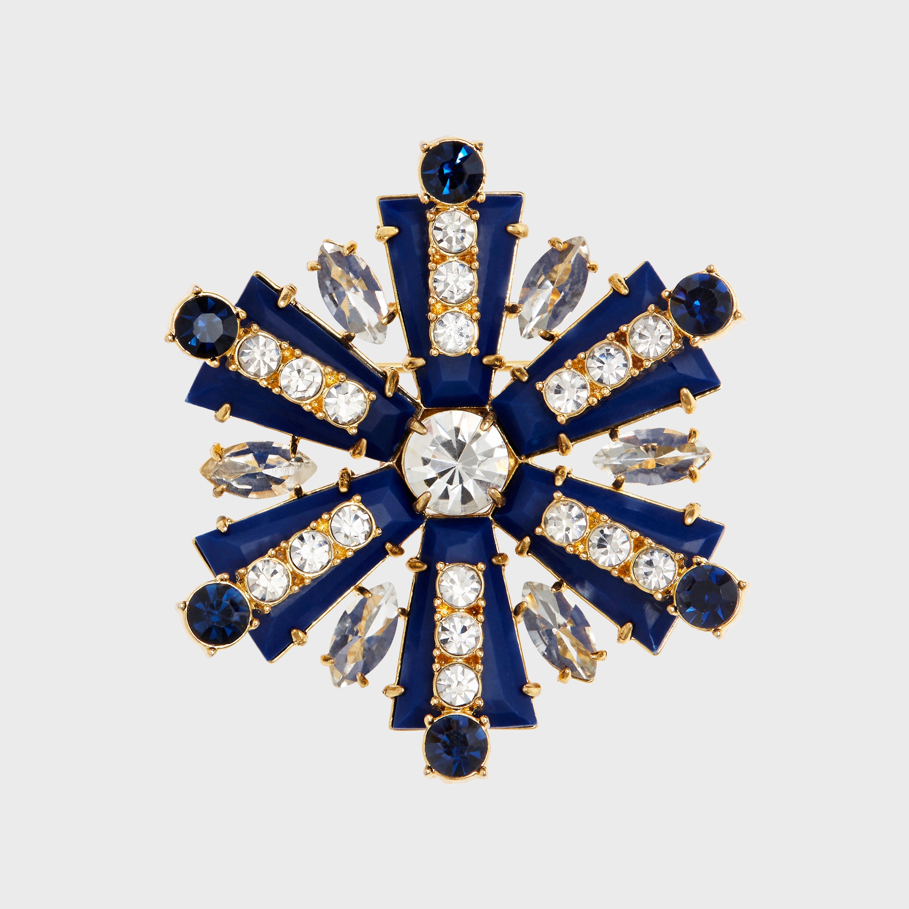 A navy and crystal brooch shaped like a starburst with a central large crystal, surrounded by smaller crystal accents and navy blue enamel.