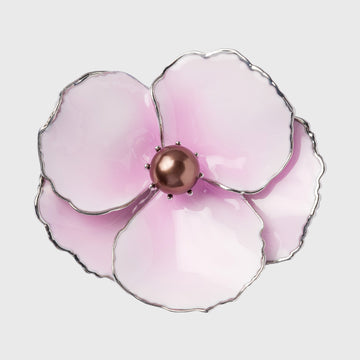 A pink enamel flower napkin ring with a metallic center and silver edging.