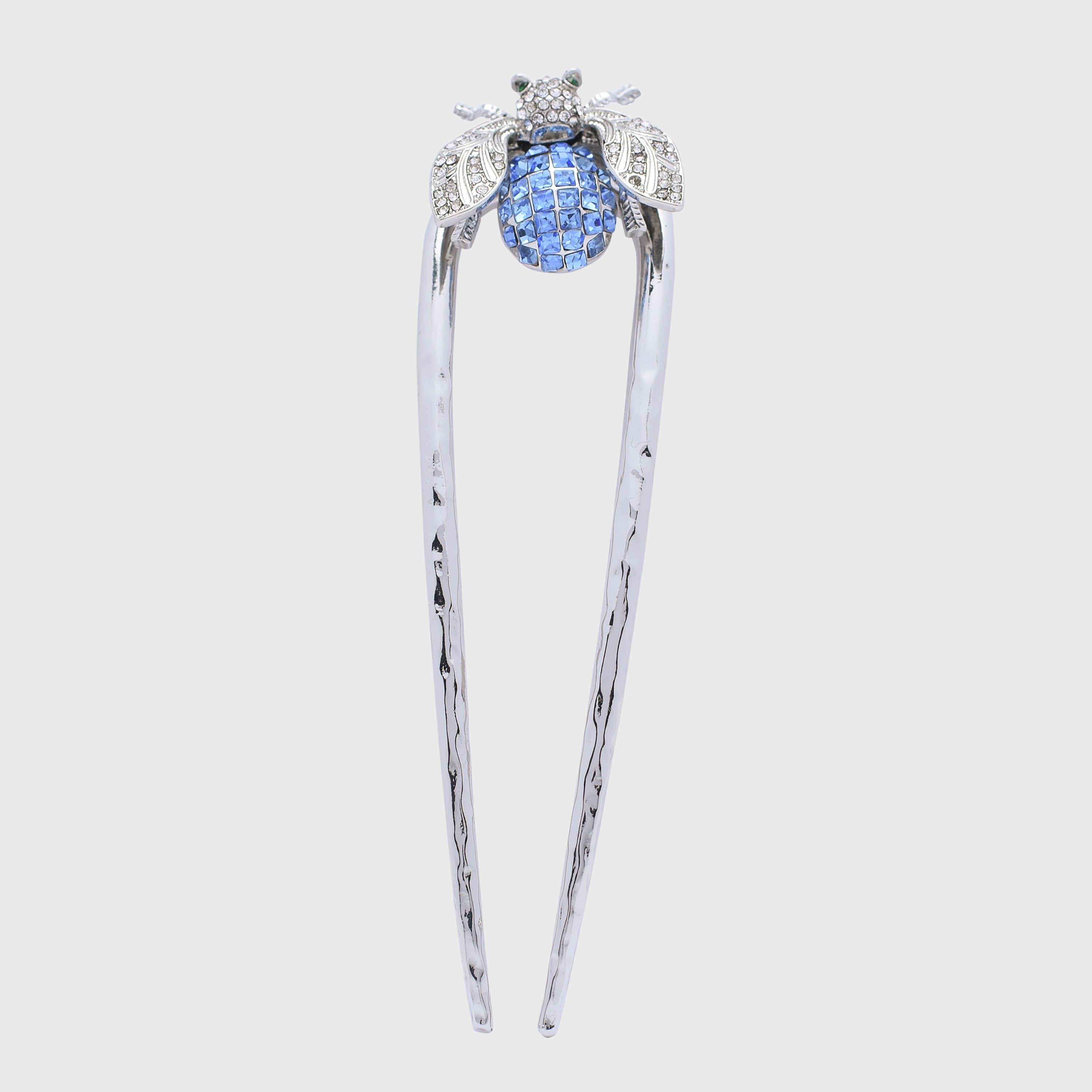 Decorative hairpin with blue gem and silver accents on a light gray background