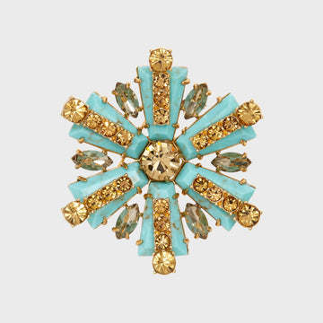 A star-shaped brooch with turquoise and gold-colored stones