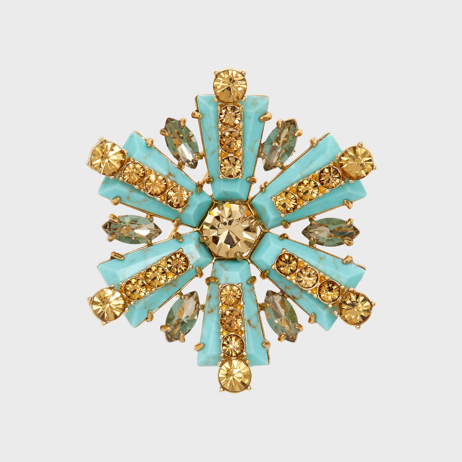 A star-shaped brooch with turquoise and gold-colored stones