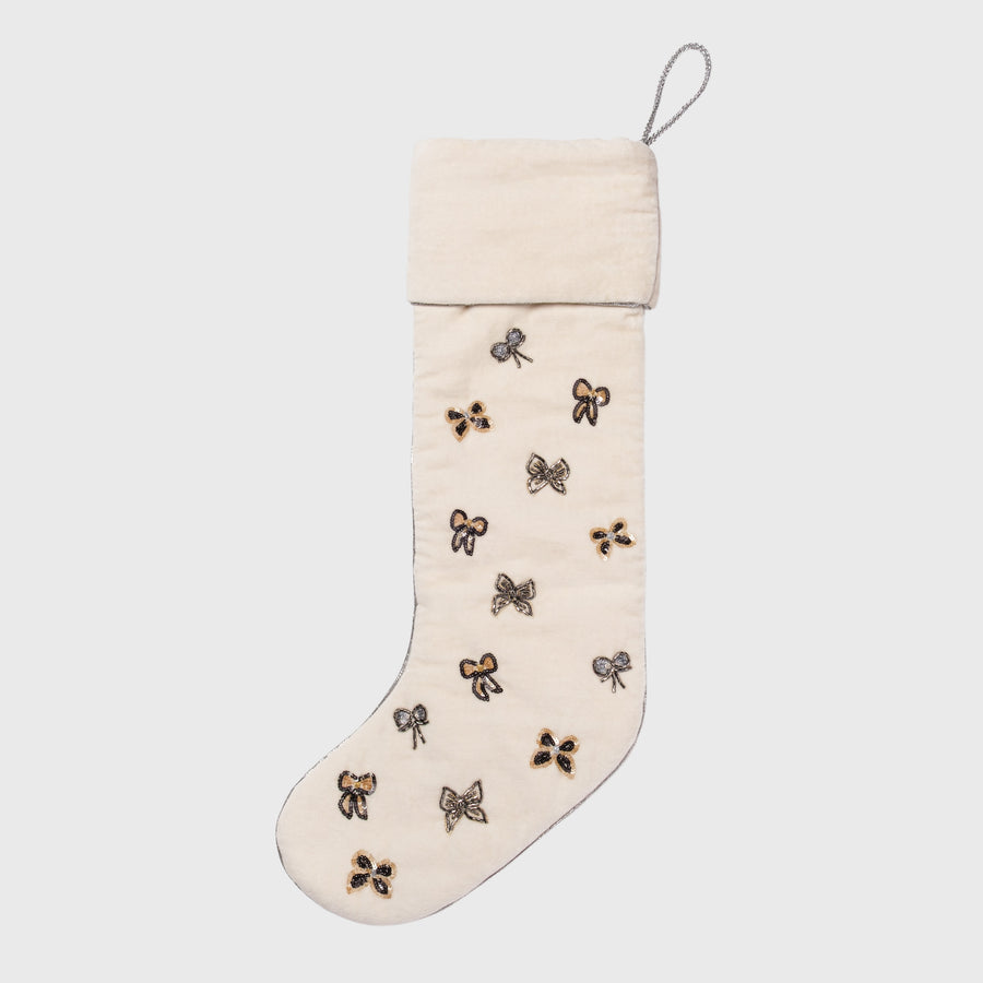 Beige Christmas stocking with decorative bows on a white background