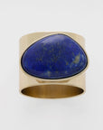 A gold-colored napkin ring with a lapis lazuli stone set in the center,
