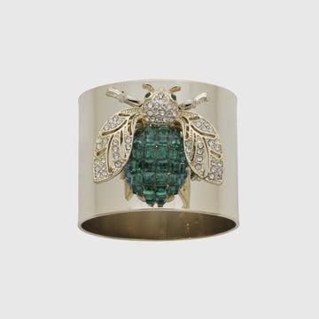 A gold-colored napkin ring featuring an emerald green bee design with sparkling embellishments.