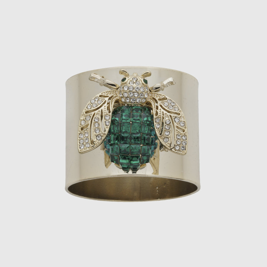 A gold-colored napkin ring featuring an emerald green bee design with sparkling embellishments.