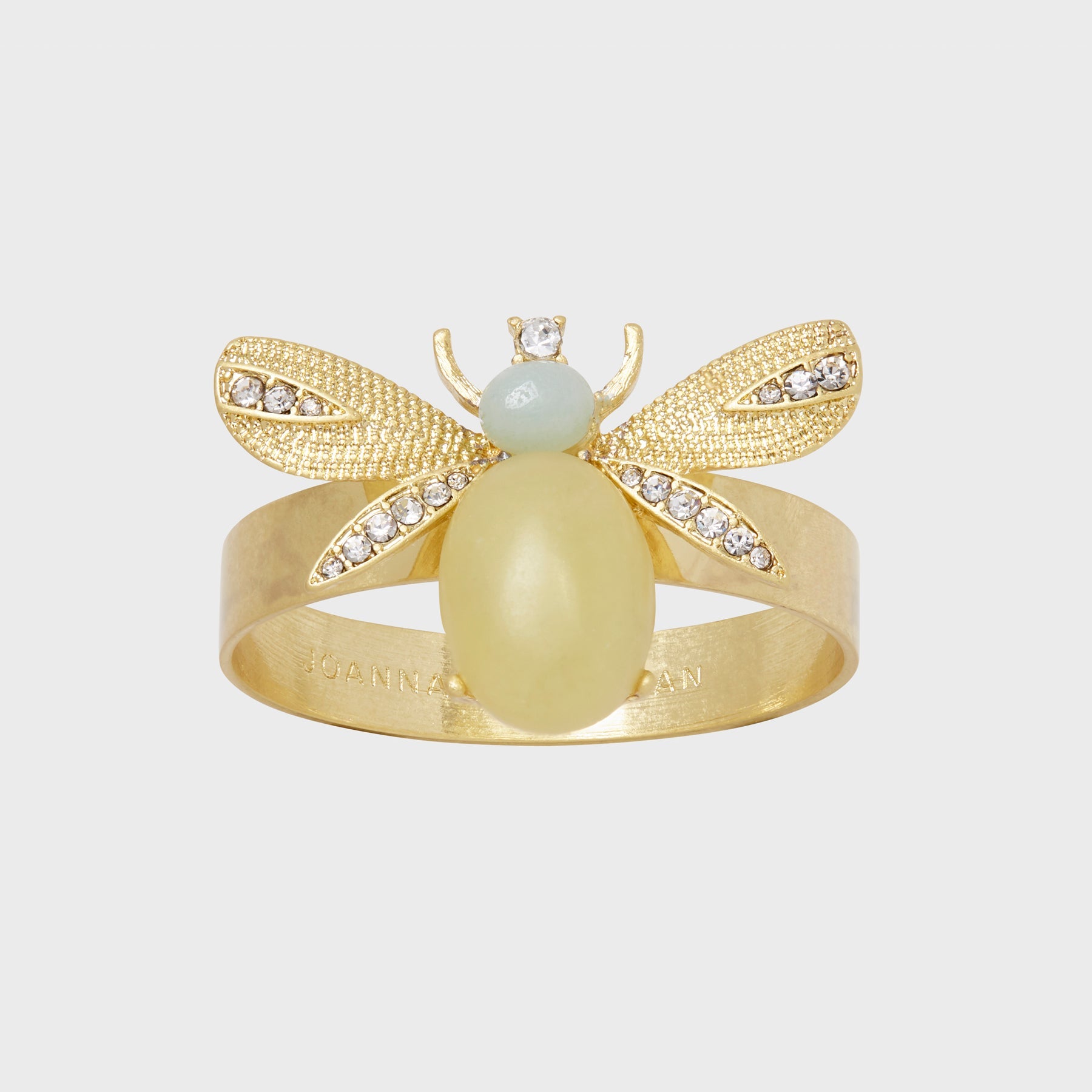 A gold-colored napkin ring featuring a semi-precious lemon jasper stone and with etched details resembling wings