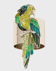 A decorative parrot napkin ring with green and yellow coloring and gold accents.