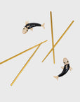 A set of golden chopsticks with black and gold enamel koi fish designs on the rests.