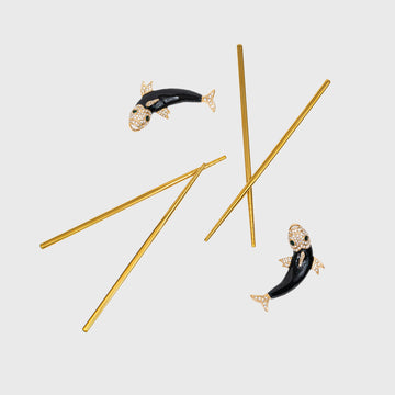 A set of golden chopsticks with black and gold enamel koi fish designs on the rests.