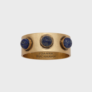 A gold-colored napkin ring featuring a lapis lazuli stone