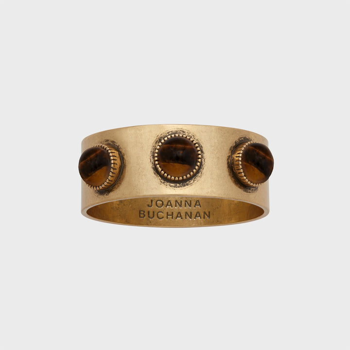 A set of brass napkin rings with a tiger's eye stone, featuring an antique gold finish.