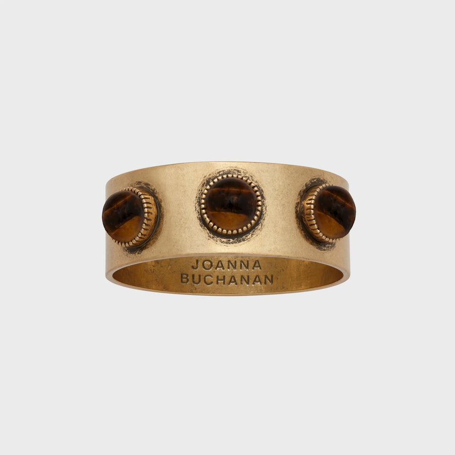 A set of brass napkin rings with a tiger's eye stone, featuring an antique gold finish.
